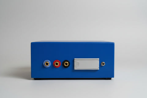 The rear view of a AMCO audiometer, featuring three audio jacks (blue, red, black) with gold-plated connectors and a blank white label area.