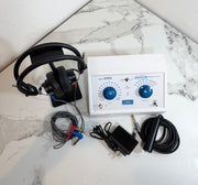 Ambco 650A Portable Screening Audiometer with attached black over-ear headphones, electrode leads, power adapter, and coiled cable, arranged on a white marble-patterned surface.