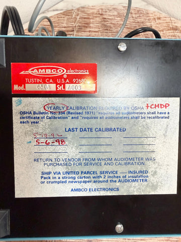 An AMBCO 650A audiometer device control unit with a black metal casing, featuring a red manufacturer label and a white OSHA compliance sticker on the front.