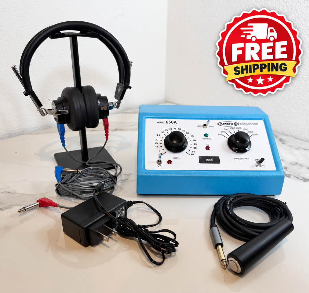 An Ambco 650A Audiometer with a blue control box, black headphones on a stand, an electrode pad, a power adapter, and a handle, displayed on a light marble surface with a white wall background. A 'FREE SHIPPING' badge is in the top right corner.