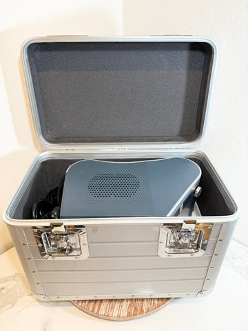 A gray BioLite Ceralas laser device inside an open silver aluminum hard case with black foam lining, photographed against a light wall.