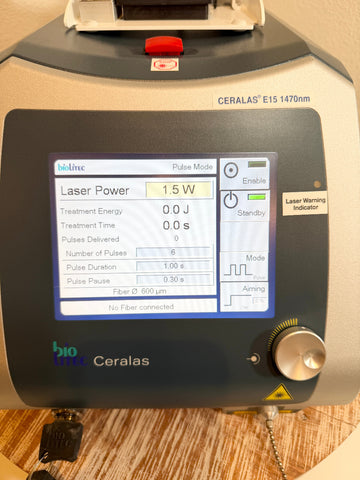A BioLite Ceralas laser device with a dark gray control panel and a digital screen displaying settings, photographed on a wooden surface.