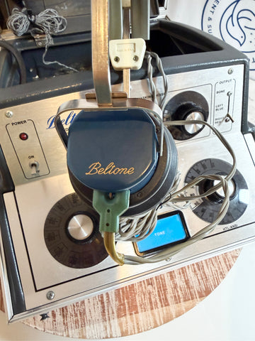 Close-up of a Beltone earbud inside an electronic device with visible branding.
