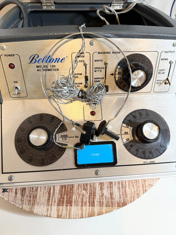 Vintage-style Beltone 120 Audiometer  equipment with 'Beltone' branding on a wooden surface.