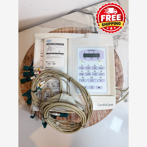 CardioCare cardiac monitor with attached lead wires and a printed instruction booklet, placed on a round wooden tray with a red 'FREE SHIPPING' badge overlay in the top right corner.