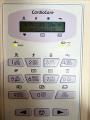 A close-up of a CardioCare medical device keypad with a small display screen and multiple numbered buttons, photographed against a plain light background.