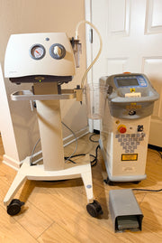 A Cynosure SmartLipo Laser System and Medela Dominant 50 Suction/Aspiration System set on a wood floor in front of a white door. 