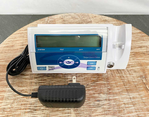 Picture of the Dentsply Tulsa Dental Model E3 Torque Control Motor with a charging adapter