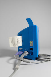 Blue GE Carescape Dinamap VC150 Vital Signs Monitor device with a receipt on a wooden surface.