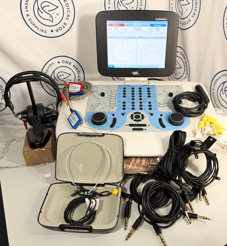 An IGL medical ultrasound gel device with a digital screen, multiple black cables, a gel sponge, and carrying cases, arranged on a white table against a branded backdrop.