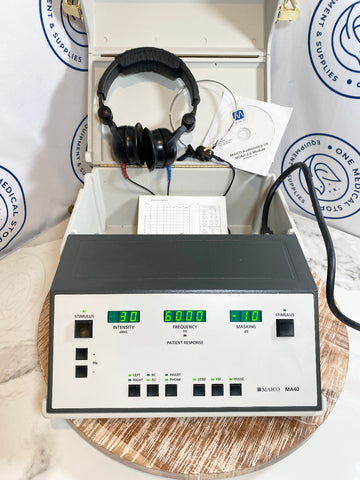 MAICO MA40 Portable Audiometer device with headphones and a CD on a wooden surface