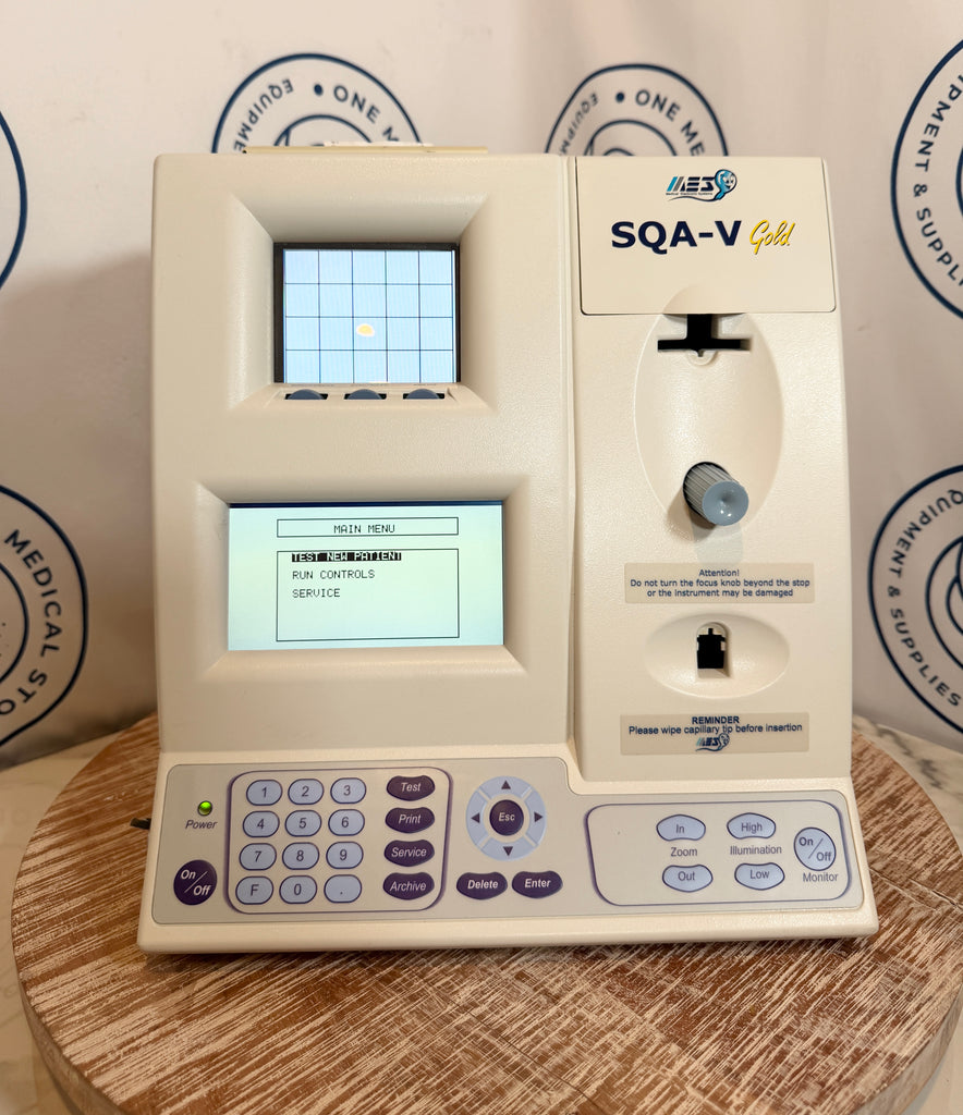 Medical device labeled 'SQA-V' on a wooden surface with a branded background.