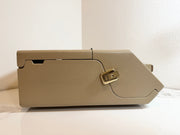 A Maico MA41 Portable Diagnostic Audiometer beige case with a brass buckle, photographed on a white surface against a white wall.