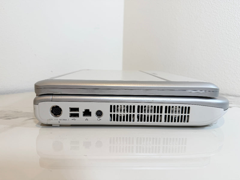 A Mindray portable ultrasound machine  shown from the side, resting on a white reflective surface against a white wall.