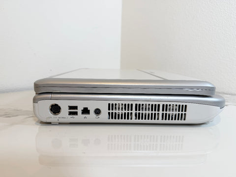 A Mindray portable ultrasound machine  shown from the side, resting on a white reflective surface against a white wall.