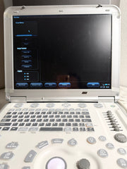 An open Mindray portable ultrasound machine with a white console, gray keyboard keys, and a black screen showing the ultrasound interface.