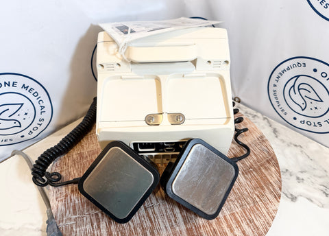 Electrodes and device on a wooden surface with a white background