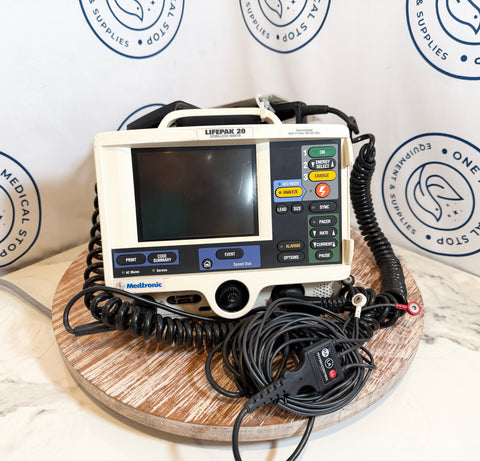Medtronic Lifepak 20 defibrillator on a wooden surface with a branded background.