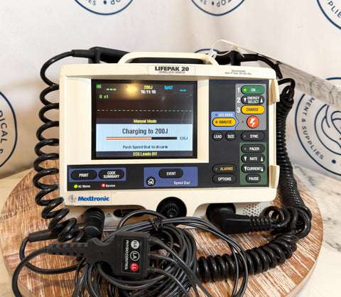 Medtronic Lifepak 20 defibrillator on a wooden surface with a white background