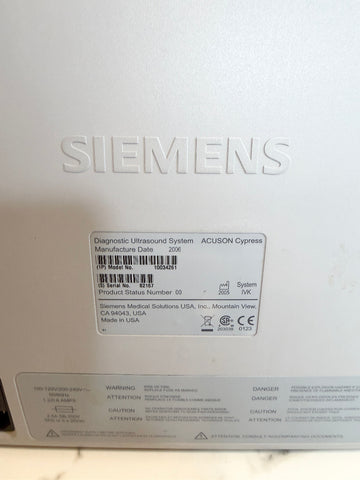 The back of a Siemens ultrasound system, showing the embossed Siemens logo, a product label with barcodes, and warning labels at the bottom.
