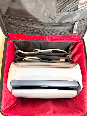 A Siemens Acuson Cypress Portable Ultrasound inside an open red and black zippered travel organizer bag with storage compartments.