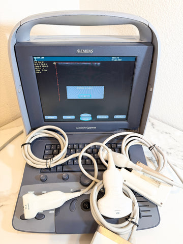 Siemens Acuson Cegressa portable ultrasound machine with a gray and black console, keyboard, and multiple white ultrasound probes and cables on a light marble surface.