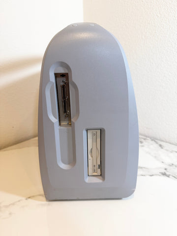 A  sideview of Siemens Acuson Cypress Portable Ultrasound standing on a white marble surface against a textured off-white wall.