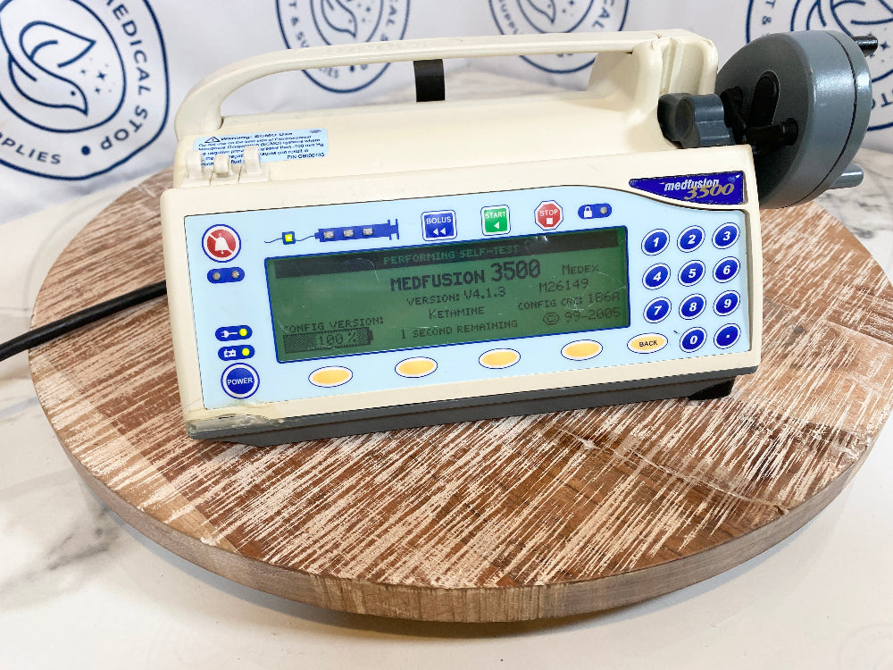 Smiths Medical Medfusion 3500 Syringe Pump with digital display and keypad on a wooden surface