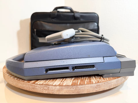 A SonoSite MicroMaxx Portable Ultrasound System, displayed on a round wooden tray with its black carrying case and cable behind it.