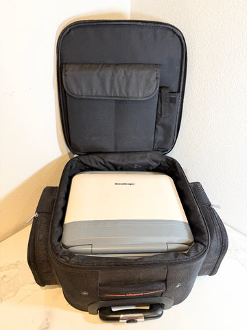 A Sonoscape ultrasound machine in a black storage bag opened upright. The bag has padded side pockets, a top handle, and a zippered opening.