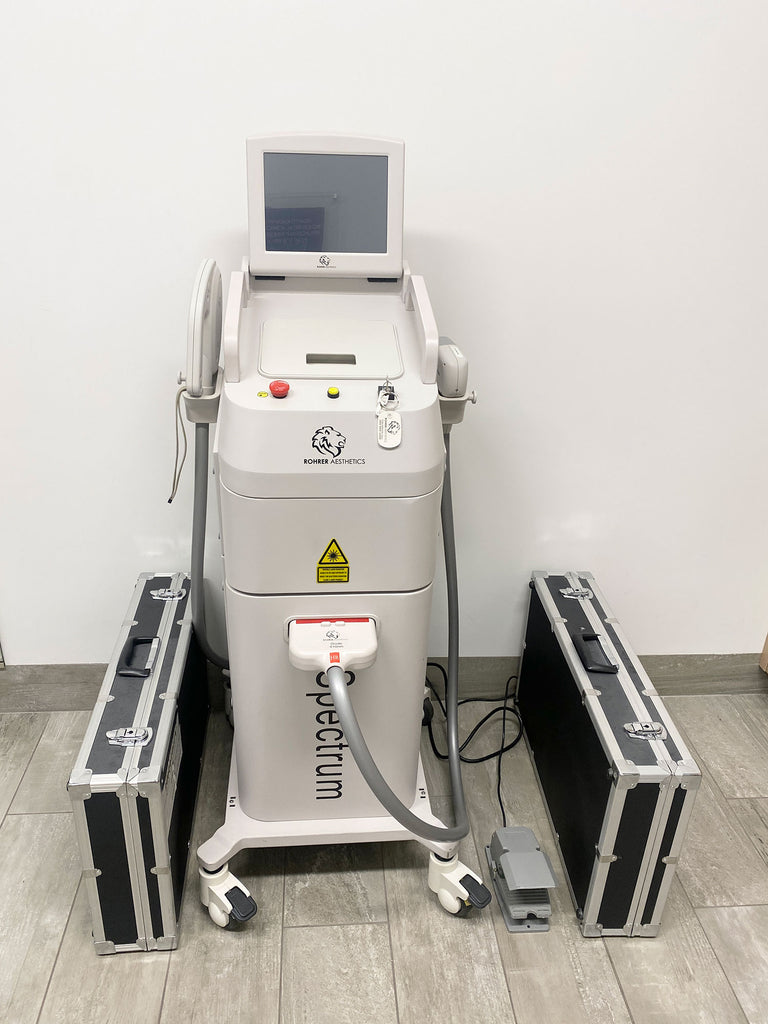 Picture of the Rohrer Spectrum Laser Hair Removal Machine with 2 case on the side of it 